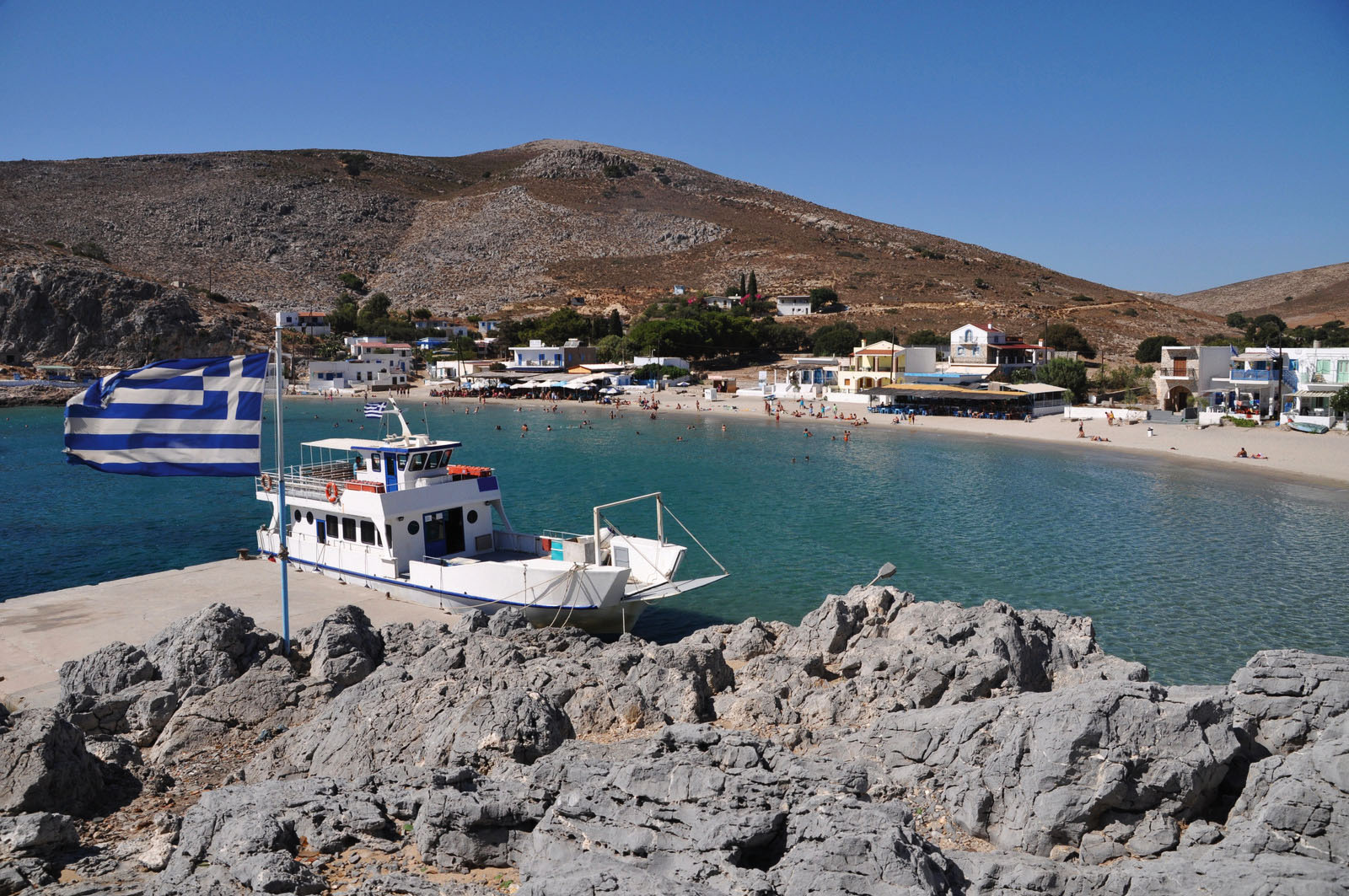 beautiful bay of Pserimos island with Greece flag