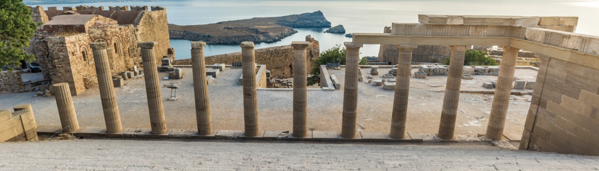 View through ancient pillars towards the sea from a beautiful acropolis of Lindos.